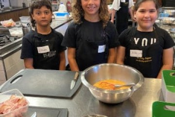 a group of people sitting at a table with food