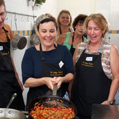 Chef Riki Kaspi works in the kitchen looked upon by cooking class students in Perth, Western Australia