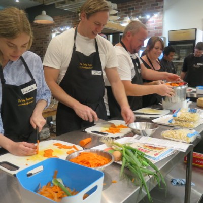 Students of Riki Kaspi's cooking class, The Cooking Professor, prepare ingredients