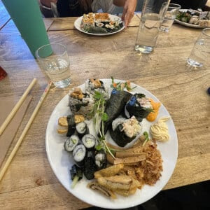 a group of people sitting at a table with a plate of food