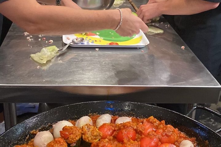 a group of people preparing food in a pan
