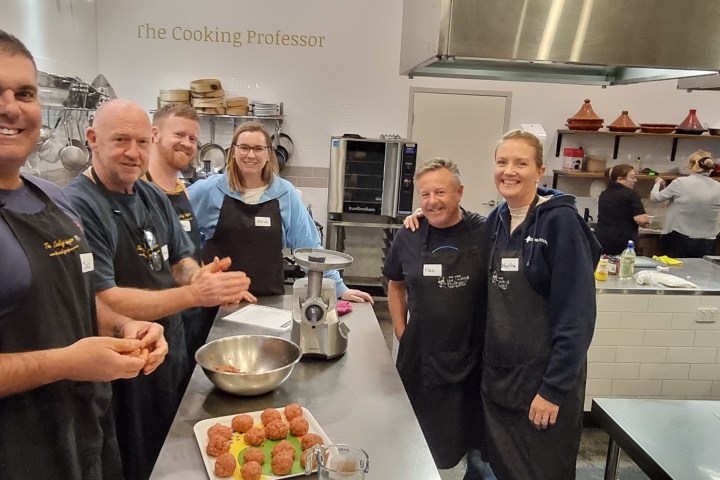 a man and woman preparing food in a kitchen