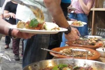 a group of people preparing food in a bowl