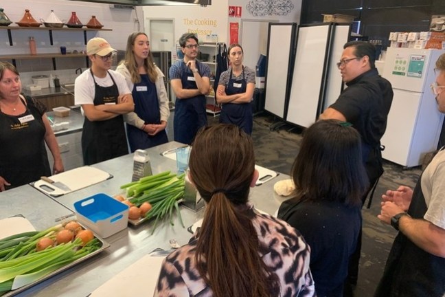 a group of people standing around a table