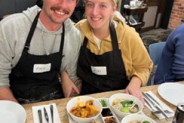 Gil Balfas et al. sitting at a table with a plate of food