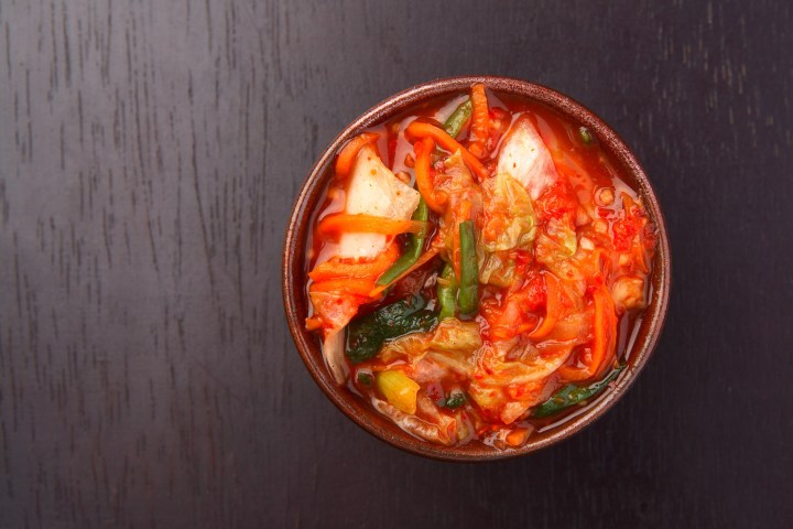 a bowl of food sitting on top of a wooden table