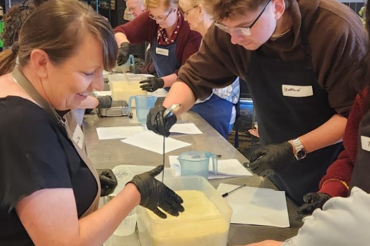 People making soap together at a workshop table.