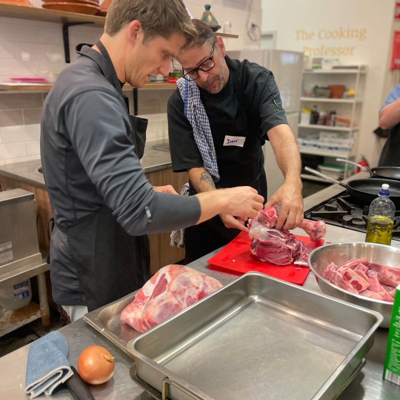 a man and woman preparing food in a kitchen
