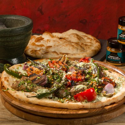 a pizza sitting on top of a wooden cutting board