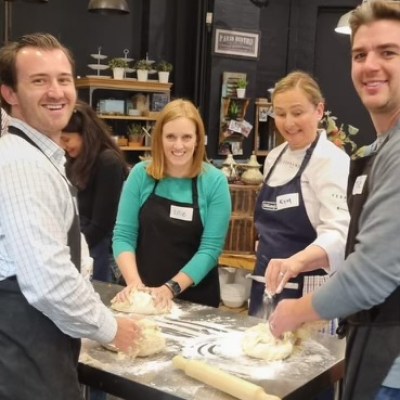a group of people standing in a kitchen preparing food