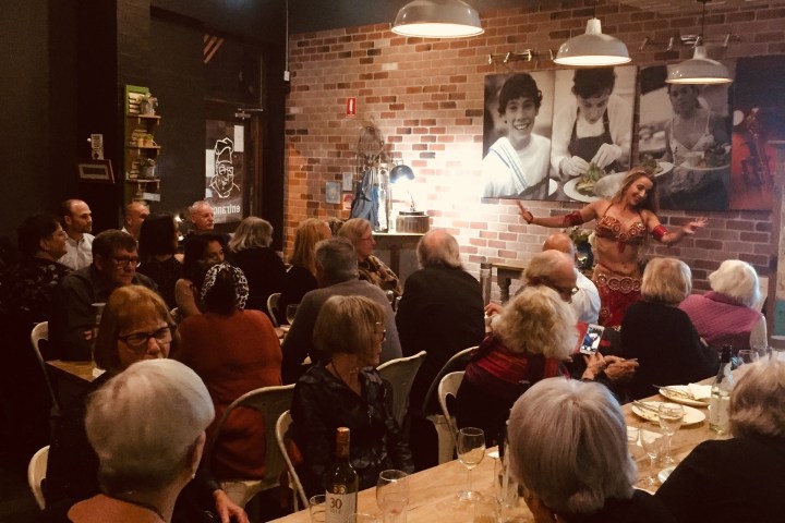 a group of people sitting at a table in front of a crowd