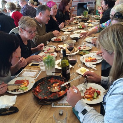 a group of people sitting at a table full of food